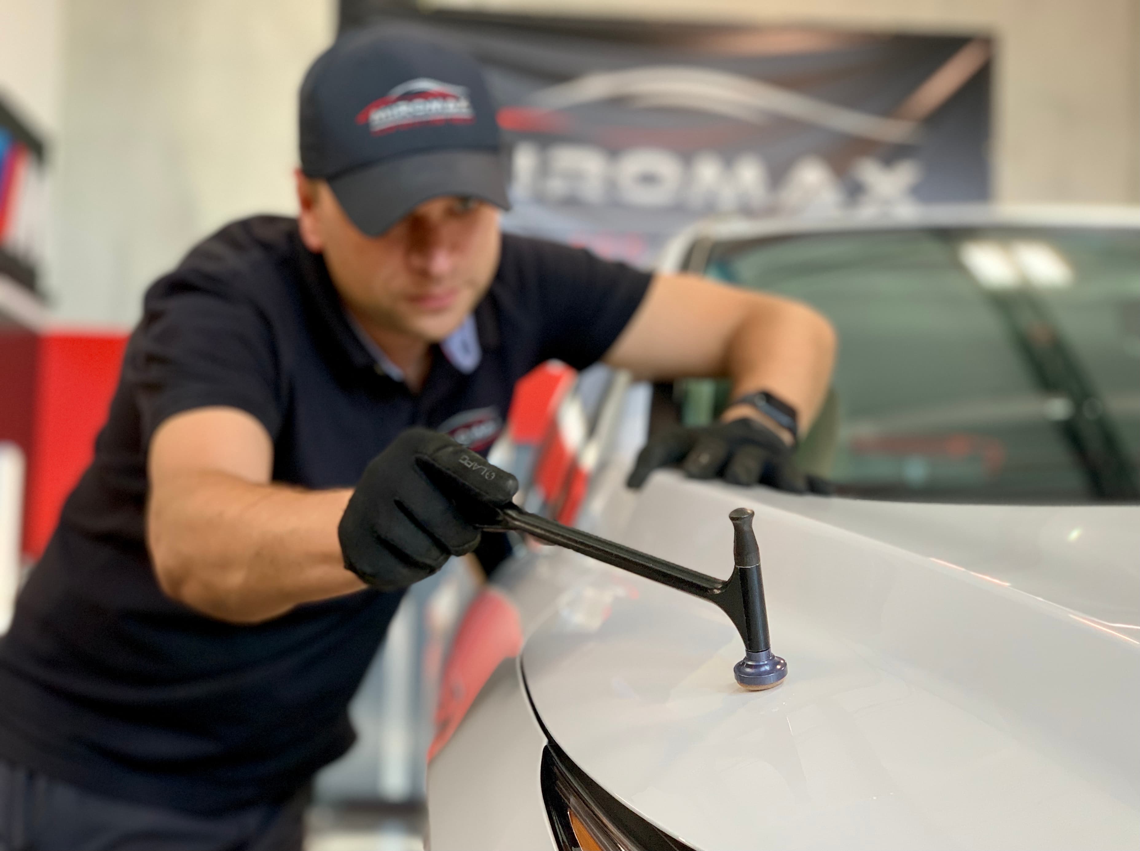 Technician fixing car with hammer tool