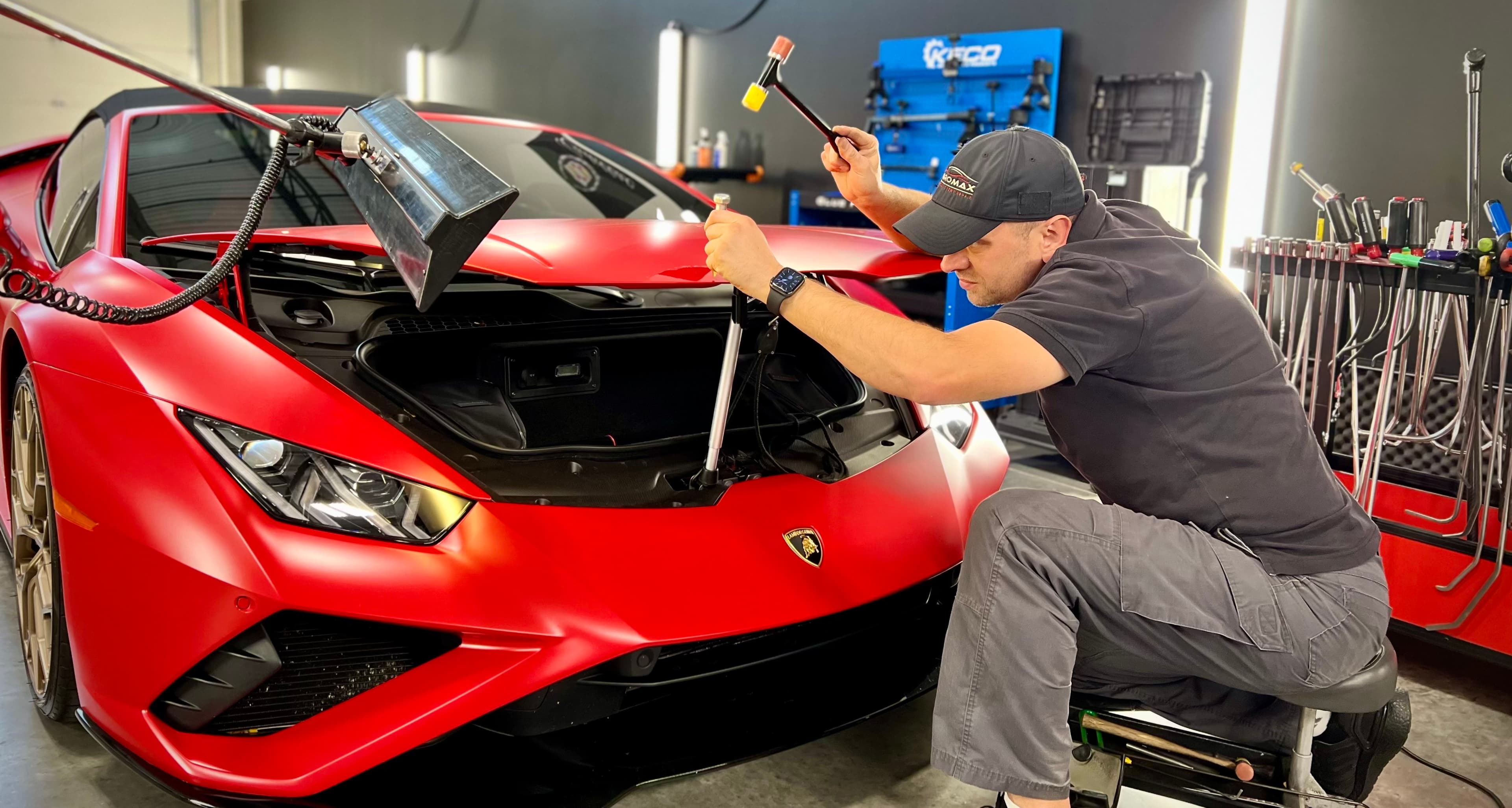 Technician repairing red Lamborghini